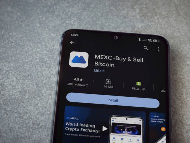 Lod, Israel - 16 Temmuz 2023: MEXC uygulama oyun mağazası sayfası seramik taş zemin üzerinde akıllı telefon. Üst görünüm düzlüğü kopyalama alanı ile yatıyordu.