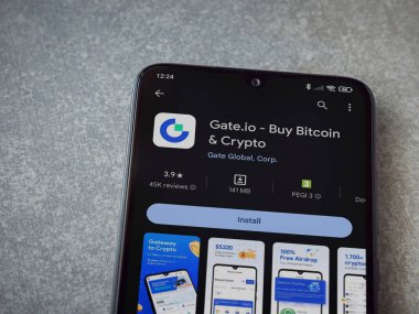 Lod, Israel - 16 Temmuz 2023: Seramik taş zemin üzerinde akıllı telefon ile Gate.io uygulaması oyun mağazası sayfası. Üst görünüm düzlüğü kopyalama alanı ile yatıyordu.
