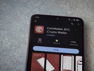 Lod, Israel - 16 Temmuz 2023: CoinWallet uygulaması seramik taş zemin üzerinde akıllı telefon oyun mağazası sayfası. Üst görünüm düzlüğü kopyalama alanı ile yatıyordu.