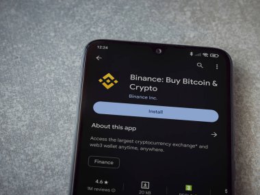 Lod, Israel - 16 Temmuz 2023: Seramik taş zemin üzerinde akıllı telefondan Binance uygulaması oyun mağazası sayfası. Üst görünüm düzlüğü kopyalama alanı ile yatıyordu.
