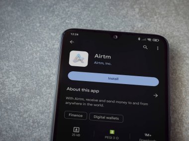 Lod, Israel - 16 Temmuz 2023: AirTM uygulama oyun mağazası sayfası seramik taş zemin üzerinde akıllı telefon. Üst görünüm düzlüğü kopyalama alanı ile yatıyordu.