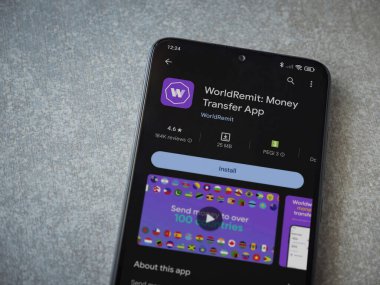 Lod, Israel - 16 Temmuz 2023: WorldRemit uygulama oyun mağazası sayfası seramik taş zemin üzerinde akıllı telefon. Üst görünüm düzlüğü kopyalama alanı ile yatıyordu.