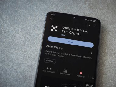 Lod, Israel - 16 Temmuz 2023: OKX uygulama oyun mağazası sayfası seramik taş zemin üzerinde akıllı telefon. Üst görünüm düzlüğü kopyalama alanı ile yatıyordu.