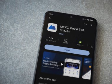 Lod, Israel - 16 Temmuz 2023: MEXC uygulama oyun mağazası sayfası seramik taş zemin üzerinde akıllı telefon. Üst görünüm düzlüğü kopyalama alanı ile yatıyordu.