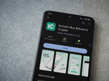 Lod, Israel - 16 Temmuz 2023: KuCoin uygulama oyun mağazası sayfası seramik taş zemin üzerinde akıllı telefon. Üst görünüm düzlüğü kopyalama alanı ile yatıyordu.