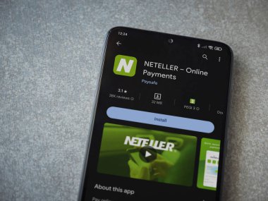 Lod, Israel - 16 Temmuz 2023: NETELLER uygulama oyun mağazası sayfası seramik taş zemin üzerinde akıllı telefon. Üst görünüm düzlüğü kopyalama alanı ile yatıyordu.