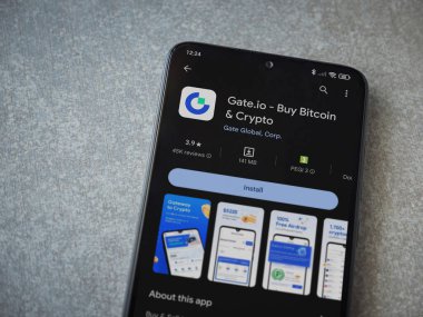 Lod, Israel - 16 Temmuz 2023: Seramik taş zemin üzerinde akıllı telefon ile Gate.io uygulaması oyun mağazası sayfası. Üst görünüm düzlüğü kopyalama alanı ile yatıyordu.