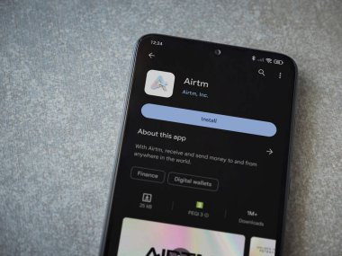 Lod, Israel - 16 Temmuz 2023: AirTM uygulama oyun mağazası sayfası seramik taş zemin üzerinde akıllı telefon. Üst görünüm düzlüğü kopyalama alanı ile yatıyordu.