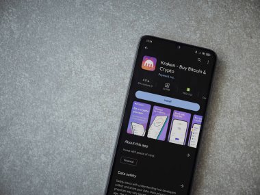Lod, Israel - 16 Temmuz 2023: Kraken uygulama oyun mağazası sayfası seramik taş zemin üzerinde akıllı telefon. Üst görünüm düzlüğü kopyalama alanı ile yatıyordu.
