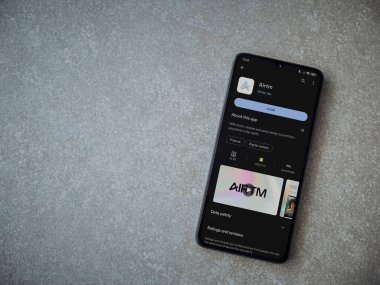 Lod, Israel - 16 Temmuz 2023: AirTM uygulama oyun mağazası sayfası seramik taş zemin üzerinde akıllı telefon. Üst görünüm düzlüğü kopyalama alanı ile yatıyordu.
