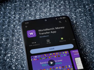 Lod, Israel - 16 Temmuz 2023: WorldRemit uygulama oyun mağazası sayfası metalik arka planda akıllı telefon. Üst görünüm yatağını kapat.
