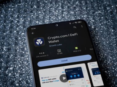 Lod, Israel - 16 Temmuz 2023: Crypto.com uygulama oyun mağazası sayfası metalik arka planda akıllı telefon. Üst görünüm yatağını kapat.