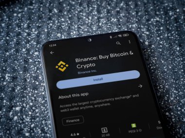 Lod, Israel - 16 Temmuz 2023: Binance uygulama oyun mağazası sayfası metalik arka planda. Üst görünüm yatağını kapat.