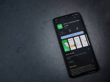 Lod, Israel - 16 Temmuz 2023: eToro uygulama oyun mağazası sayfası kara mermer taşlı arka planda. Üst görünüm düzlüğü kopyalama alanı ile yatıyordu.