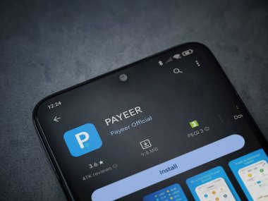 Lod, Israel - 16 Temmuz 2023: PaYEER uygulama oyun mağazası sayfası kara mermer taşlı arka planda. Üst görünüm düzlüğü kopyalama alanı ile yatıyordu.