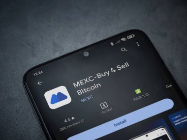 Lod, Israel - 16 Temmuz 2023: MEXC uygulama oyun mağazası sayfası kara mermer taşlı arka planda akıllı telefon. Üst görünüm düzlüğü kopyalama alanı ile yatıyordu.