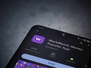 Lod, Israel - 16 Temmuz 2023: WorldRemit uygulama oyun mağazası sayfası kara mermer taşlı arka planda. Üst görünüm düzlüğü kopyalama alanı ile yatıyordu.