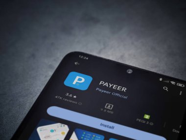 Lod, Israel - 16 Temmuz 2023: PaYEER uygulama oyun mağazası sayfası kara mermer taşlı arka planda. Üst görünüm düzlüğü kopyalama alanı ile yatıyordu.