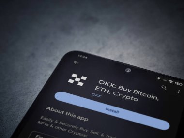 Lod, Israel - 16 Temmuz 2023: OKX uygulama oyun mağazası sayfası kara mermer taşlı arka planda akıllı telefon. Üst görünüm düzlüğü kopyalama alanı ile yatıyordu.