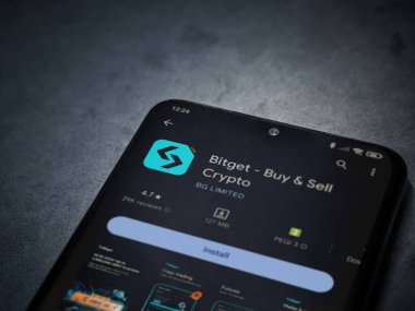 Lod, Israel - 16 Temmuz 2023: Bitget app playshop page on smartphone on a dark mermer stone background. Üst görünüm düzlüğü kopyalama alanı ile yatıyordu.