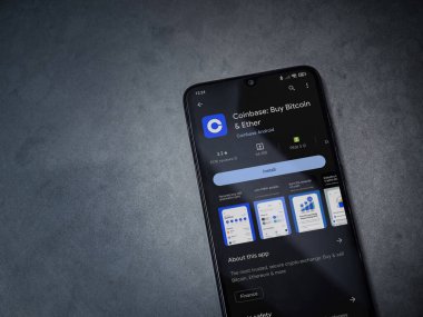 Lod, Israel - 16 Temmuz 2023: Koyu mermer taşlı arka planda akıllı telefondan sikke bazlı uygulama oyun mağazası sayfası. Üst görünüm düzlüğü kopyalama alanı ile yatıyordu.