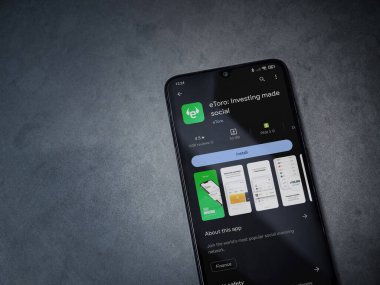 Lod, Israel - 16 Temmuz 2023: eToro uygulama oyun mağazası sayfası kara mermer taşlı arka planda. Üst görünüm düzlüğü kopyalama alanı ile yatıyordu.