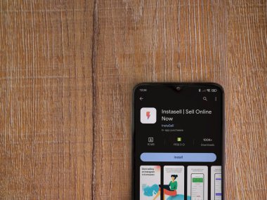 Lod, Israel - 16 Temmuz 2023: Instasell uygulama oyun mağazası sayfası ahşap zemin üzerinde akıllı telefon. Üst görünüm düzlüğü kopyalama alanı ile yatıyordu.