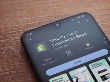 Lod, Israel - 16 Temmuz 2023: Ahşap arka planda akıllı telefon uygulaması oyun mağazası sayfası. Üst görünüm düzlüğü kopyalama alanı ile yatıyordu.