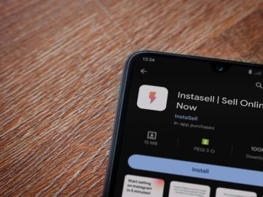 Lod, Israel - 16 Temmuz 2023: Instasell uygulama oyun mağazası sayfası ahşap zemin üzerinde akıllı telefon. Üst görünüm düzlüğü kopyalama alanı ile yatıyordu.