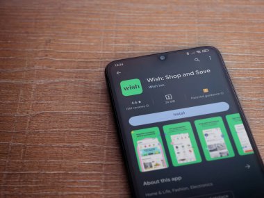 Lod, Israel - 16 Temmuz 2023: Ahşap arka planda akıllı telefondan dilek uygulaması oyun mağazası sayfası. Üst görünüm düzlüğü kopyalama alanı ile yatıyordu.