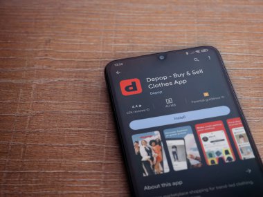 Lod, Israel - 16 Temmuz 2023: Depop uygulaması oyun mağazası sayfası ahşap zemin üzerinde akıllı telefon. Üst görünüm düzlüğü kopyalama alanı ile yatıyordu.