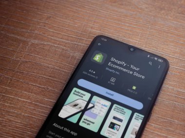 Lod, Israel - 16 Temmuz 2023: Ahşap arka planda akıllı telefon uygulaması oyun mağazası sayfası. Üst görünüm düzlüğü kopyalama alanı ile yatıyordu.
