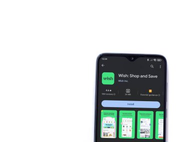 Lod, Israel - 16 Temmuz 2023: Dilek uygulaması oyun mağazası sayfası beyaz zemin üzerinde akıllı telefon. Üst görünüm düzlüğü kopyalama alanı ile yatıyordu.