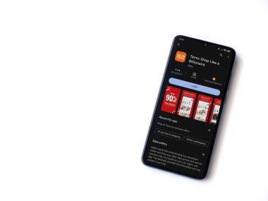 Lod, Israel - 16 Temmuz 2023: Temu app oyun mağazası sayfası beyaz arka planda akıllı telefon. Üst görünüm düzlüğü kopyalama alanı ile yatıyordu.