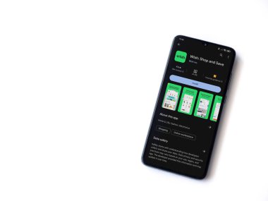 Lod, Israel - 16 Temmuz 2023: Dilek uygulaması oyun mağazası sayfası beyaz zemin üzerinde akıllı telefon. Üst görünüm düzlüğü kopyalama alanı ile yatıyordu.