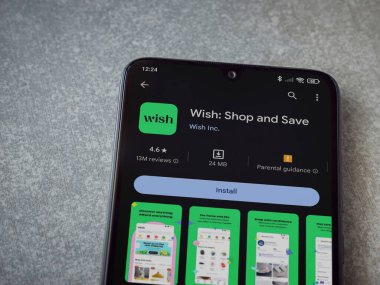 Lod, Israel - 16 Temmuz 2023: Seramik taş zemin üzerinde akıllı telefondan dilek uygulaması oyun mağazası sayfası. Üst görünüm düzlüğü kopyalama alanı ile yatıyordu.