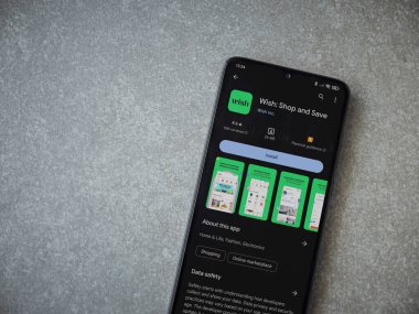 Lod, Israel - 16 Temmuz 2023: Seramik taş zemin üzerinde akıllı telefondan dilek uygulaması oyun mağazası sayfası. Üst görünüm düzlüğü kopyalama alanı ile yatıyordu.