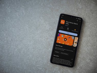 Lod, Israel - 16 Temmuz 2023: Etsy app oyun mağazası sayfası seramik taş zemin üzerinde akıllı telefon. Üst görünüm düzlüğü kopyalama alanı ile yatıyordu.