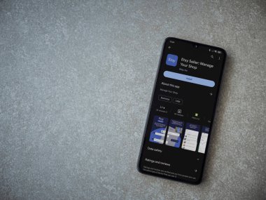 Lod, Israel - 16 Temmuz 2023: Etsy Seller uygulama oyun mağazası sayfası seramik taş zemin üzerinde akıllı telefon. Üst görünüm düzlüğü kopyalama alanı ile yatıyordu.