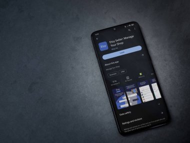 Lod, Israel - 16 Temmuz 2023: Etsy Seller uygulama oyun mağazası sayfası kara mermer taşlı arka planda. Üst görünüm düzlüğü kopyalama alanı ile yatıyordu.