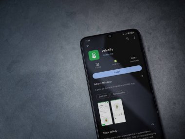 Lod, Israel - 16 Temmuz 2023: Uygulama oyun mağazası sayfasını koyu mermer bir arka planda akıllı telefondan bas. Üst görünüm düzlüğü kopyalama alanı ile yatıyordu.