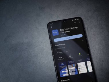 Lod, Israel - 16 Temmuz 2023: Etsy Seller uygulama oyun mağazası sayfası kara mermer taşlı arka planda. Üst görünüm düzlüğü kopyalama alanı ile yatıyordu.