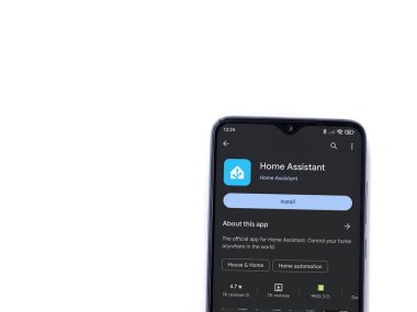 Lod, Israel - July 16,2023: Home Assistant app play store page on smartphone on white background. Top view flat lay with copy space.