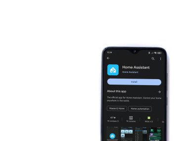 Lod, Israel - July 16,2023: Home Assistant app play store page on smartphone on white background. Top view flat lay with copy space.