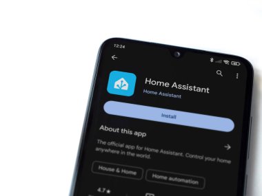 Lod, Israel - July 16,2023: Home Assistant app play store page on smartphone on white background. Top view flat lay with copy space.