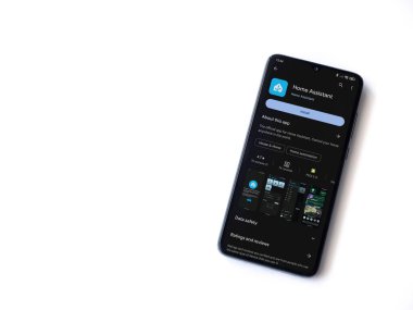 Lod, Israel - July 16,2023: Home Assistant app play store page on smartphone on white background. Top view flat lay with copy space.