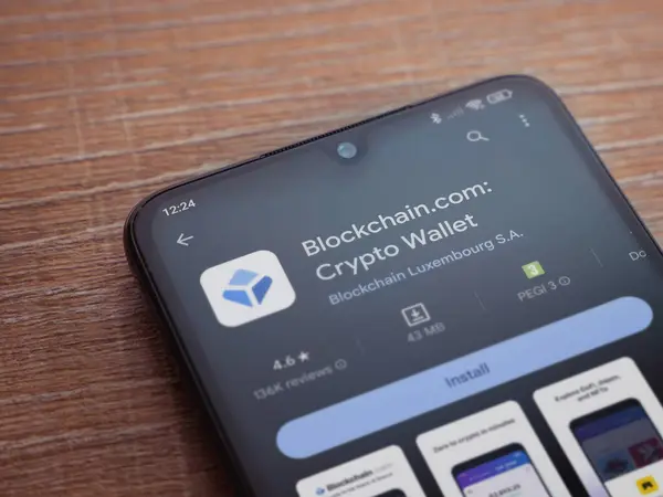 stock image Lod, Israel - July 16,2023: Blockchain.com app play store page on smartphone on wooden background. Top view flat lay with copy space.