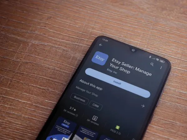 Lod, Israel - 16 Temmuz 2023: Etsy Seller uygulama oyun mağazası sayfası ahşap arka planda akıllı telefon. Üst görünüm düzlüğü kopyalama alanı ile yatıyordu.