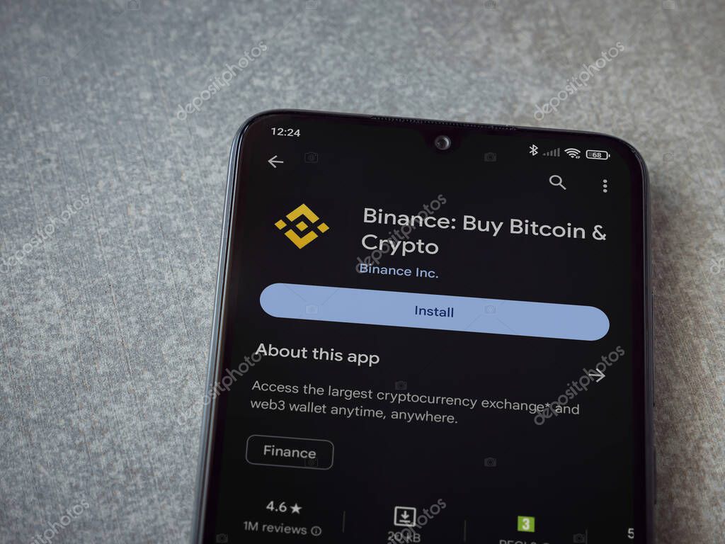 Lod, Israel - July 16,2023: Binance app play store page on smartphone on ceramic stone background. Top view flat lay with copy space.