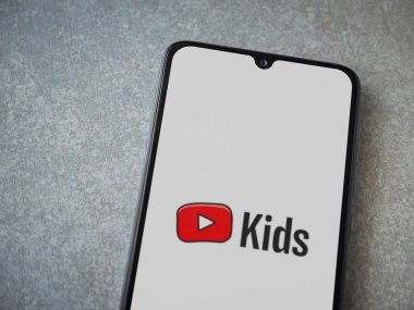 Lod, Israel - 16 Temmuz 2023: YouTube Kids uygulaması seramik taş zemin üzerinde akıllı telefondan çalıştırma ekranı. Üst görünüm düzlüğü kopyalama alanı ile yatıyordu.